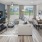 1-Bedroom Luxury Apartments in Winter Haven, FL - Prose Cypress Pointe - Living Room with Premium Plank Flooring, Large Windows, a Ceiling Fan, TV Hung on a Blue Wall, and Decorative Rug